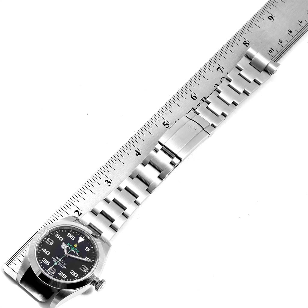 The image shows the entire Rolex Air-King 116900 Men's Stainless Steel Black Dial 116900 Men's Stainless Steel Black Dial watch, including the face, bezel, and bracelet, placed next to a ruler for scale.