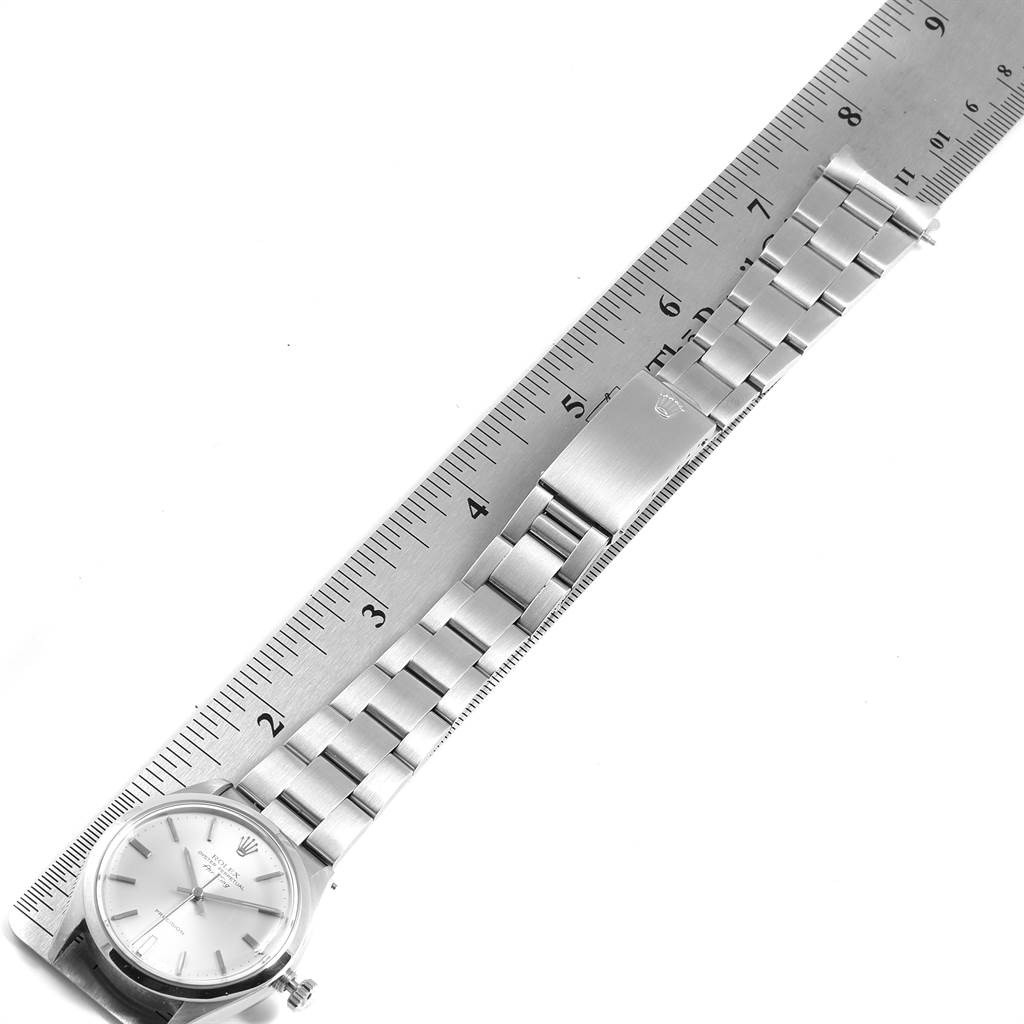 The image shows the Rolex Air-King 5500 Men's Stainless Steel Silver Dial 5500 Men's Stainless Steel Silver Dial watch laid flat with its band extended alongside a ruler for measurement.