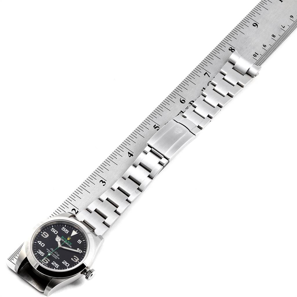 The Rolex Air-King 116900 Men's Stainless Steel Black Dial 116900 Men's Stainless Steel Black Dial watch is shown from a top-down angle, displayed next to a ruler.