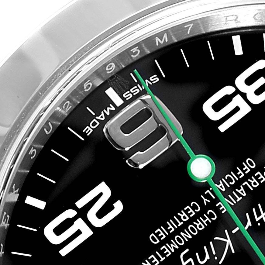This close-up image of the Rolex Air-King 116900 Men's Stainless Steel Black Dial 116900 Men's Stainless Steel Black Dial watch shows part of the dial, including hour markers, "Swiss Made" text, and the green seconds hand.