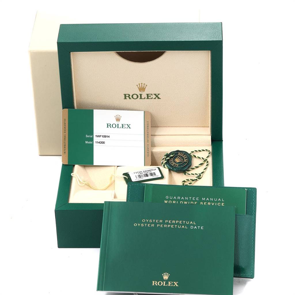 The image shows the packaging, warranty card, manuals, and tags for a Rolex Oyster Perpetual 114200 Men's Stainless Steel Silver Dial 114200 Men's Stainless Steel Silver Dial watch.