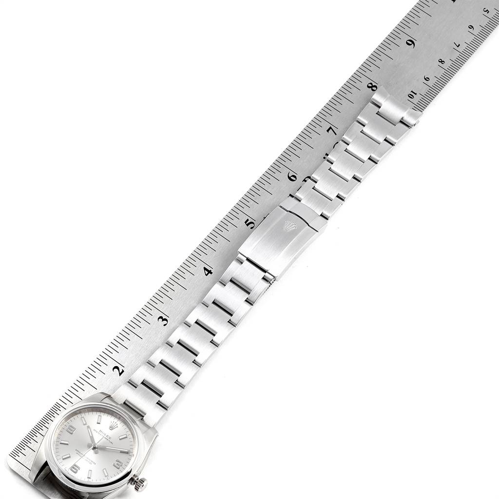 The image shows a Rolex Oyster Perpetual 114200 Men's Stainless Steel Silver Dial 114200 Men's Stainless Steel Silver Dial watch laid flat with a ruler measuring the bracelet and clasp.
