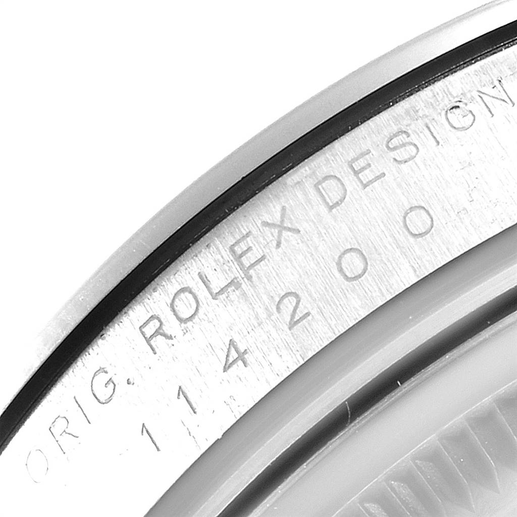 The image shows a close-up of the caseback engraving on the Rolex Oyster Perpetual 114200 Men's Stainless Steel Silver Dial 114200 Men's Stainless Steel Silver Dial watch.