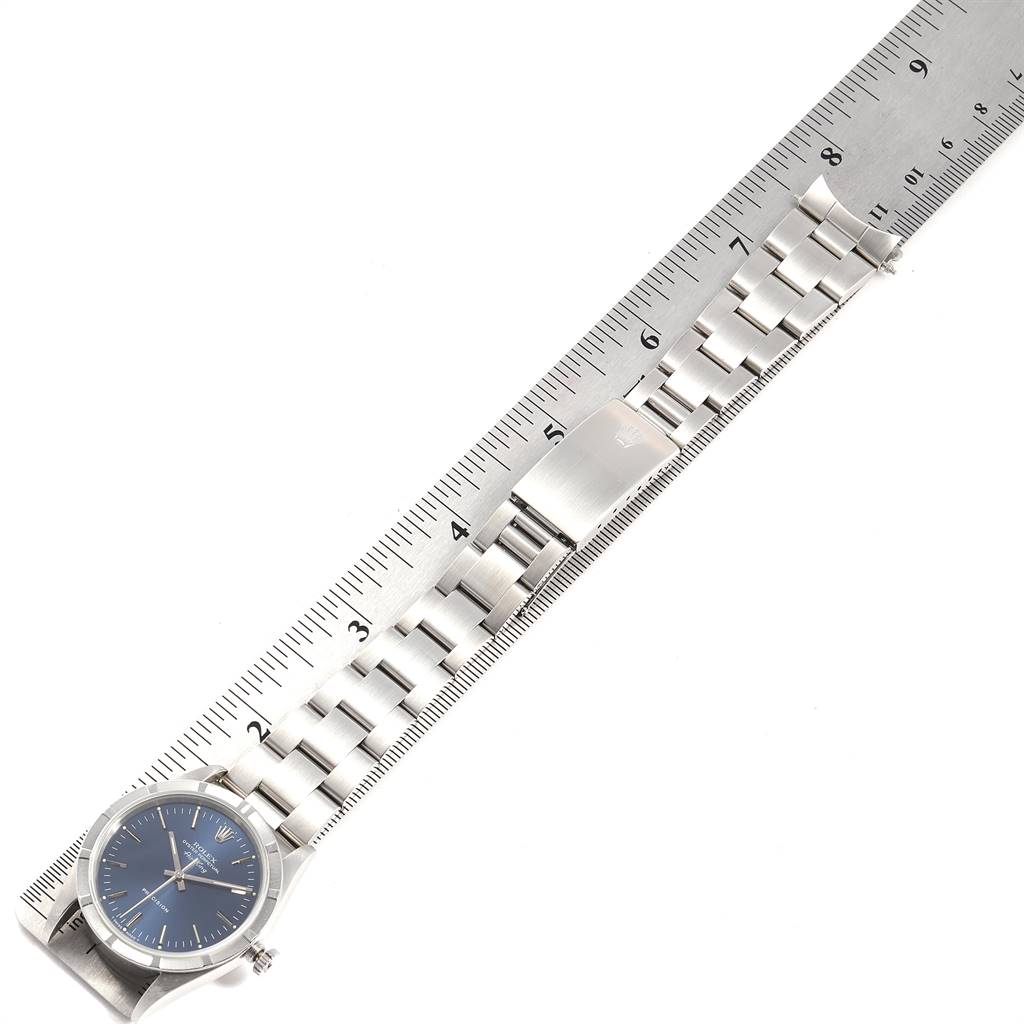 The image shows the Rolex Air-King 14010 Men's Stainless Steel Blue Dial 14010 Men's Stainless Steel Blue Dial watch laid flat next to a ruler, displaying its face, band, and clasp.