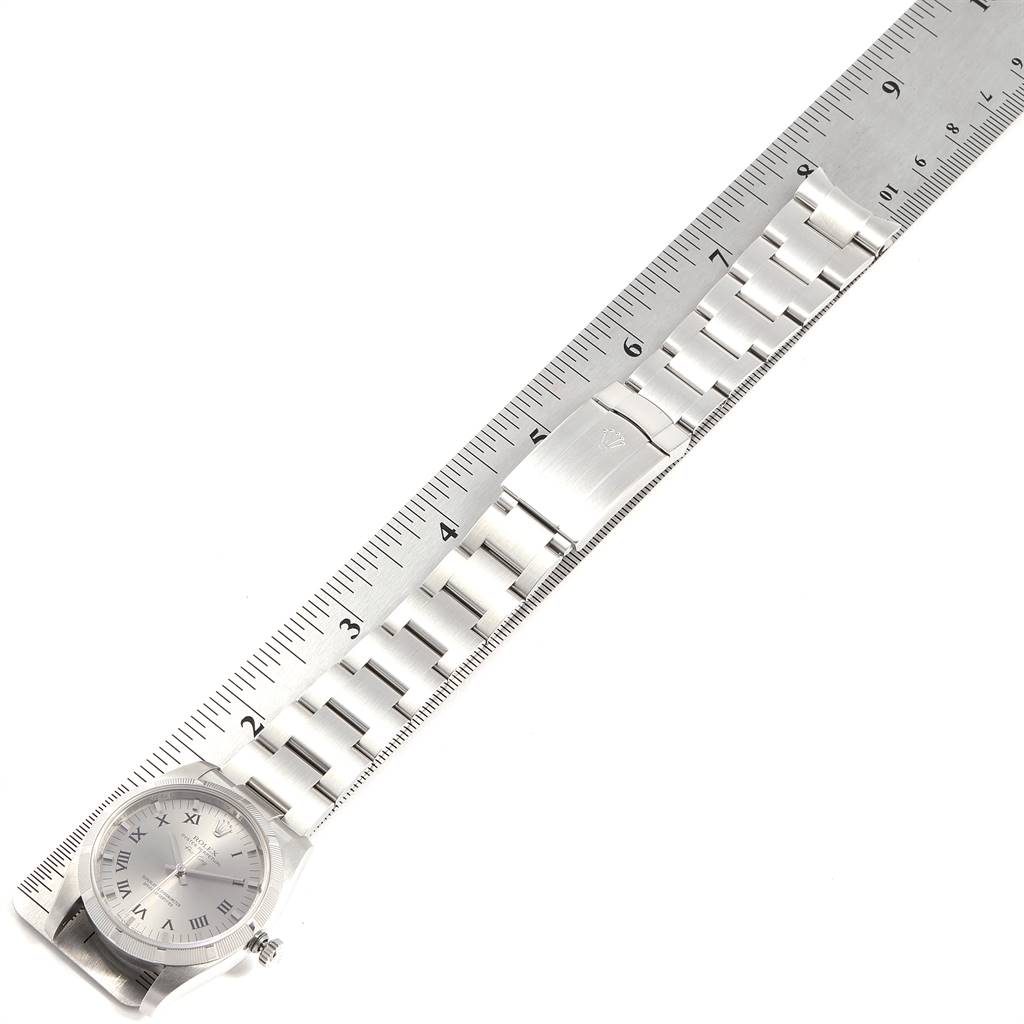 This image shows a Rolex Air-King 114210 Men's Stainless Steel Grey Dial 114210 Men's Stainless Steel Grey Dial watch placed against a metal ruler, displaying the full watch face and bracelet.