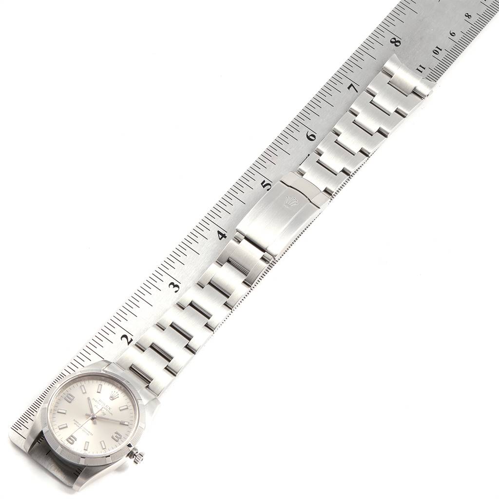 This image shows the front view of a Rolex Air-King 114210 Men's Stainless Steel Silver Dial 114210 Men's Stainless Steel Silver Dial watch, including its bracelet and clasp, alongside a ruler.