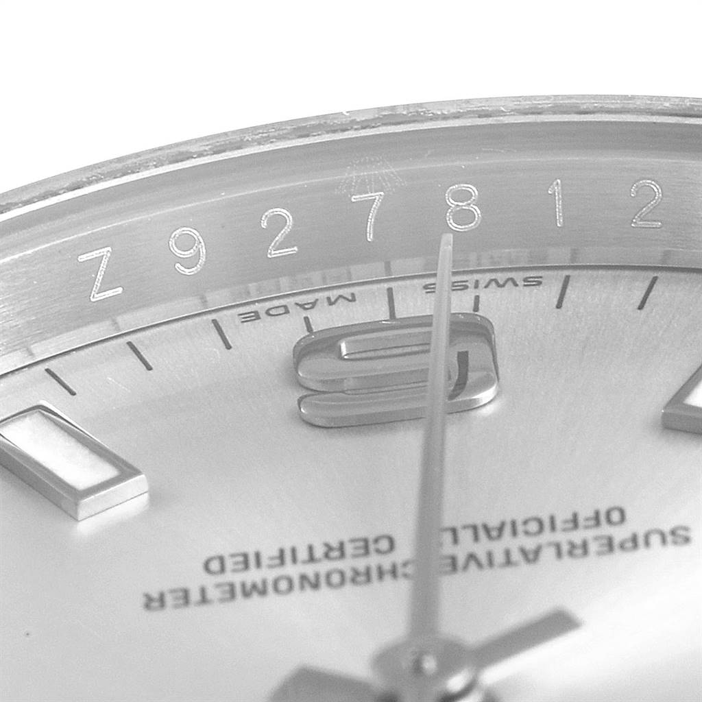 The image shows a close-up of the Rolex Air-King 114210 Men's Stainless Steel Silver Dial 114210 Men's Stainless Steel Silver Dial watch, focusing on the dial and markings near the 9 o'clock position.