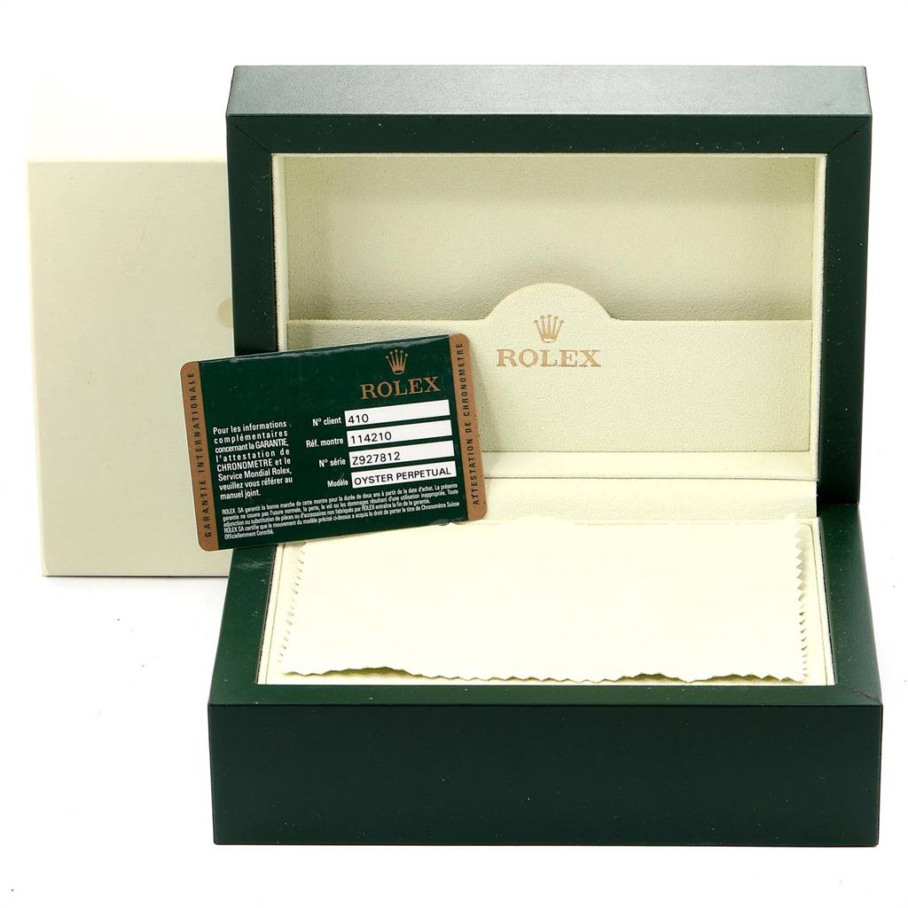 The image shows a Rolex Air-King 114210 Men's Stainless Steel Silver Dial 114210 Men's Stainless Steel Silver Dial watch box with a warranty card and a cleaning cloth.