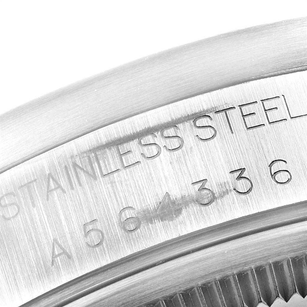 This close-up image of a Rolex Air-King 14010 Men's Stainless Steel Silver Dial 14010 Men's Stainless Steel Silver Dial watch shows part of the stainless steel case and the engraved serial number.