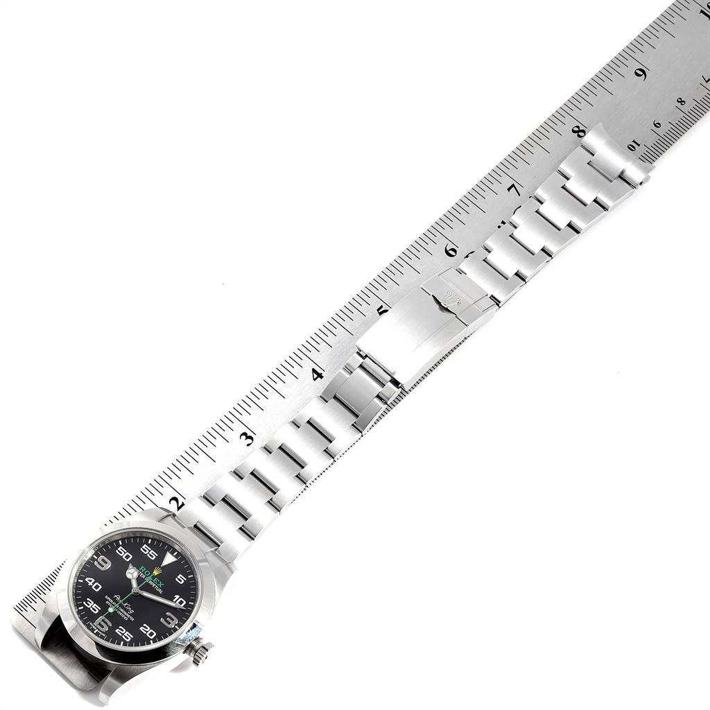 This image shows the Rolex Air-King 116900 Men's Stainless Steel Black Dial 116900 Men's Stainless Steel Black Dial watch fully extended with a ruler for measurement, displaying the face, bracelet, and clasp.