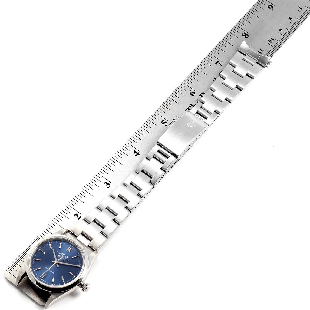 The Rolex Air-King 14000 Men's Stainless Steel Blue Dial 14000 Men's Stainless Steel Blue Dial watch is shown horizontally with its band fully extended alongside a ruler.