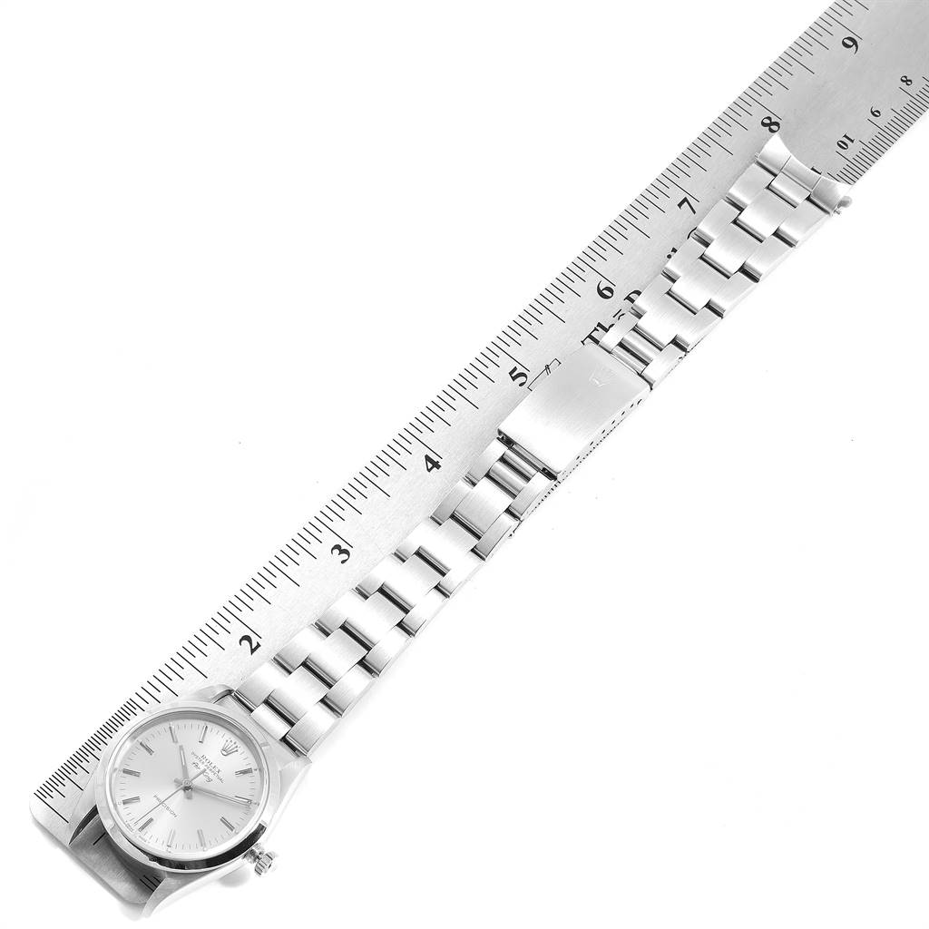 The image shows an overhead view of a Rolex Air-King 14000 Men's Stainless Steel Silver Dial 14000 Men's Stainless Steel Silver Dial watch and its bracelet next to a ruler.