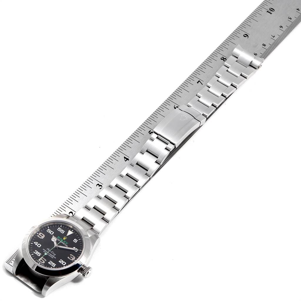 The image shows a top view of a Rolex Air-King 116900 Men's Stainless Steel Black Dial 116900 Men's Stainless Steel Black Dial watch, focusing on its full band and face, placed next to a ruler.
