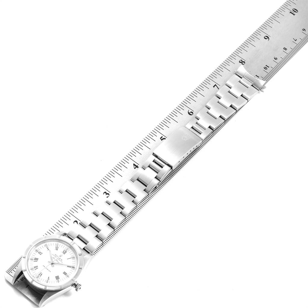 The image shows a top-down view of a Rolex Air-King 14010 Men's Stainless Steel White Dial 14010 Men's Stainless Steel White Dial watch and its bracelet next to a ruler for measurement.