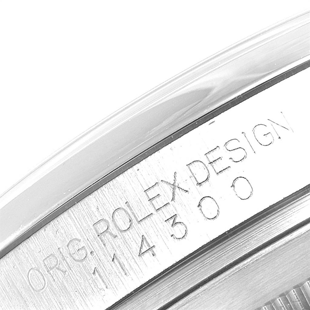 This image shows a close-up of the side of the bezel and case of the Rolex Oyster Perpetual 114300 Men's Stainless Steel Silver Dial 114300 Men's Stainless Steel Silver Dial watch, featuring its engraved serial number.