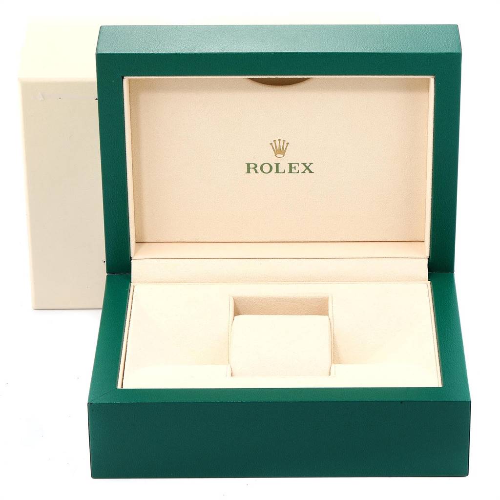 The image shows an open green and beige Rolex box for the Oyster Perpetual model.