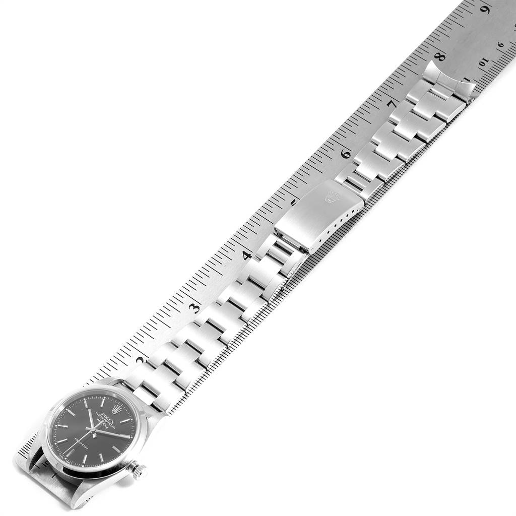 The Rolex Air-King 14000 Men's Stainless Steel Black Dial 14000 Men's Stainless Steel Black Dial watch is shown from a top-down angle, displaying its face, stainless steel bracelet, and a ruler for scale.