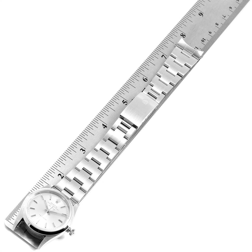 The image shows a top-down view of a Rolex Air-King 14000 Men's Stainless Steel Silver Dial 14000 Men's Stainless Steel Silver Dial watch, specifically highlighting its face and metal bracelet alongside a ruler.