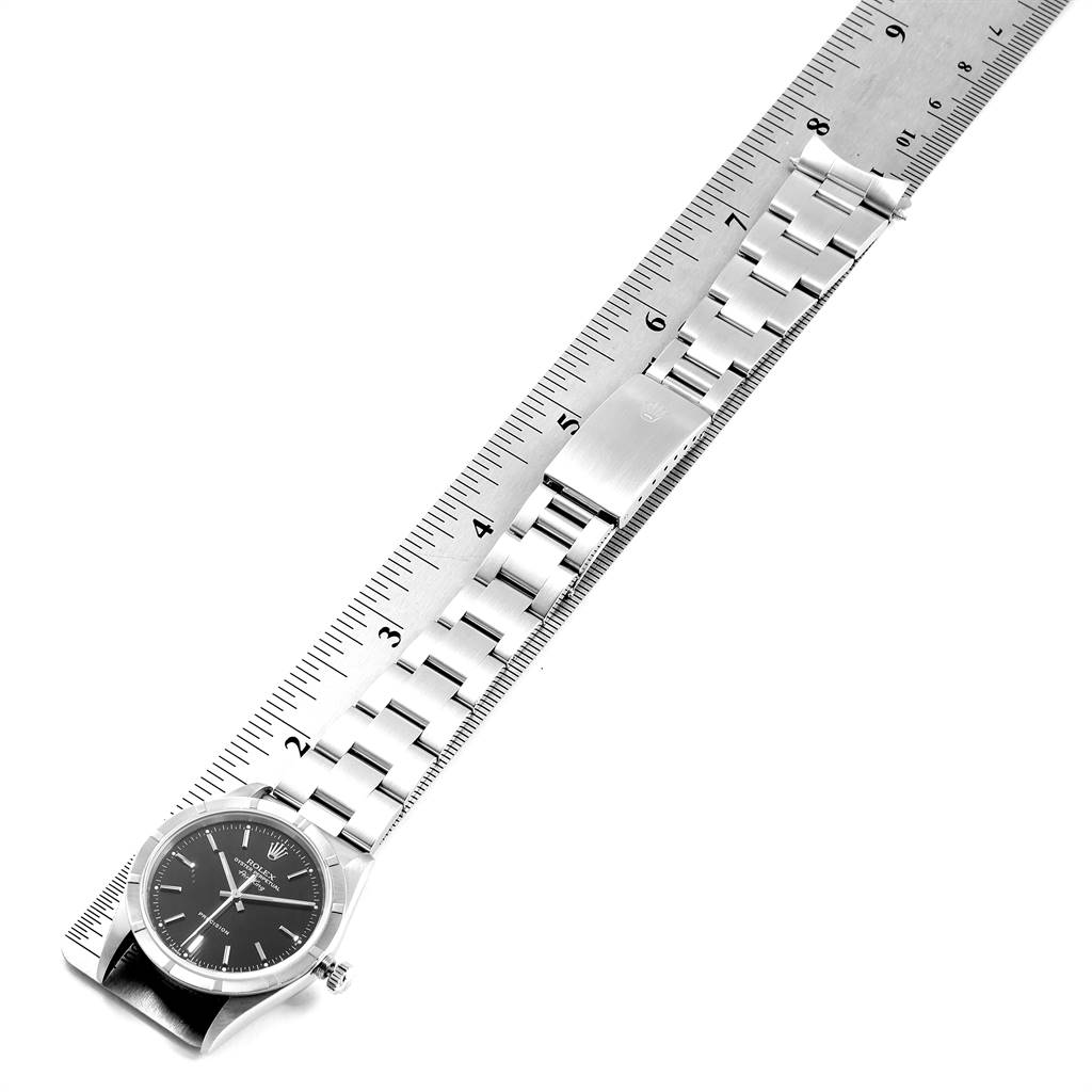 This image shows the Rolex Air-King 14010 Men's Stainless Steel Black Dial 14010 Men's Stainless Steel Black Dial watch laid flat with its bracelet and clasp extended along a ruler from an overhead angle.