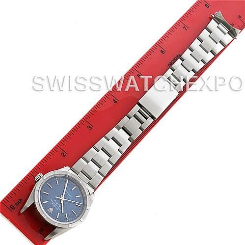 The image shows a top-down view of a Rolex Air-King 14010 Men's Stainless Steel Blue Dial 14010 Men's Stainless Steel Blue Dial watch laid beside a red ruler.