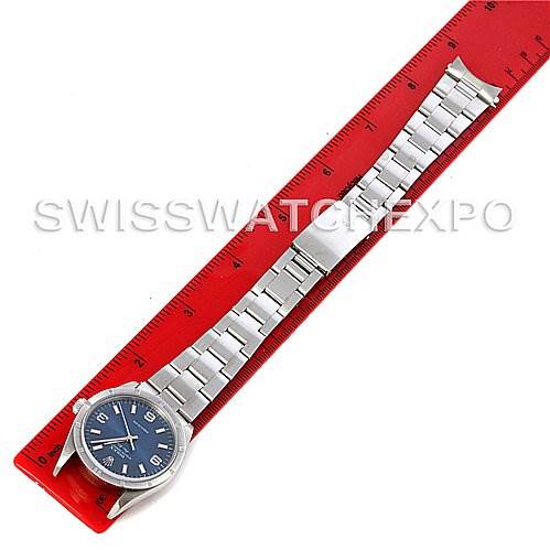 The image shows a Rolex Air-King 14010 Men's Stainless Steel Blue Dial 14010 Men's Stainless Steel Blue Dial watch laid flat parallel to a red ruler, displaying its face, bracelet, and clasp.