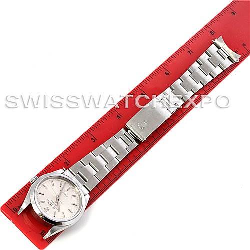 The Rolex Air-King 14000M Men's Stainless Steel Silver Dial 14000M Men's Stainless Steel Silver Dial watch is shown in a top-down angle, displaying the face, bracelet, and clasp fully extended on a red ruler.
