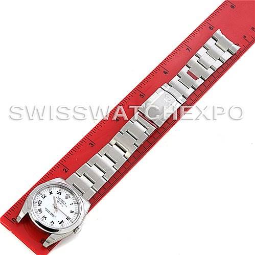 The Rolex Air-King 114200 Men's Stainless Steel White Dial 114200 Men's Stainless Steel White Dial watch is shown from a top-down angle, fully extended with the bracelet aligned next to a red ruler.