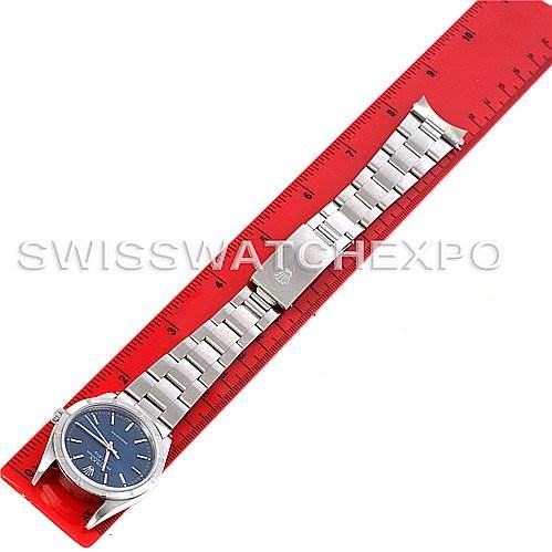 The Rolex Air-King 14010 Men's Stainless Steel Blue Dial 14010 Men's Stainless Steel Blue Dial watch is shown in a top-down view, displaying the watch face, bracelet, and clasp laid out next to a red ruler.