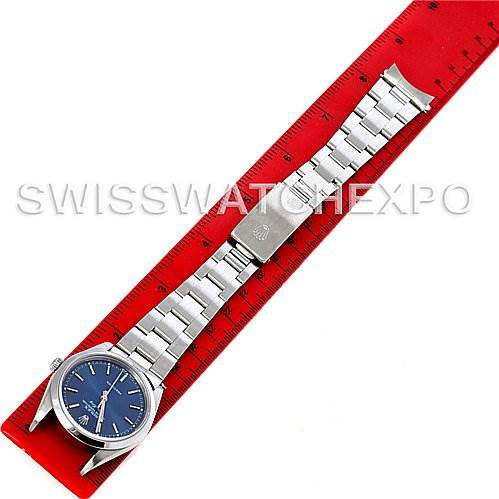 The Rolex Air-King 14000 Men's Stainless Steel Blue Dial 14000 Men's Stainless Steel Blue Dial watch is shown from an overhead angle, displayed laid out flat against a red ruler.