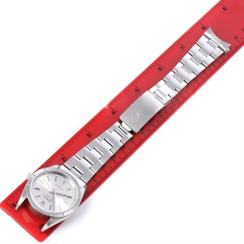 The image shows a top-down view of a Rolex Air-King 14010 Men's Stainless Steel Silver Dial 14010 Men's Stainless Steel Silver Dial watch with a silver bracelet next to a red ruler for scale.