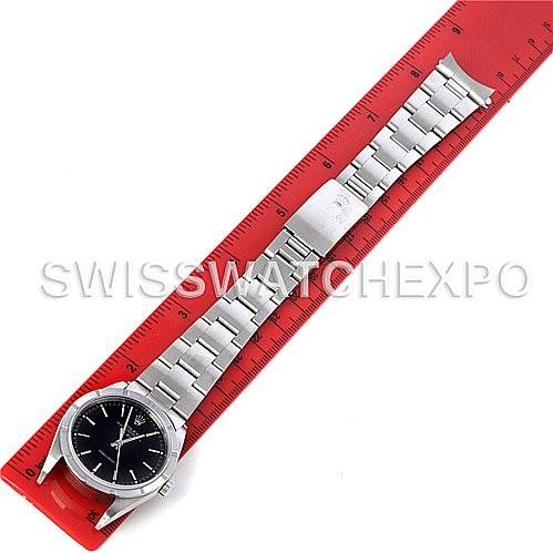 The Rolex Air-King 14010 Men's Stainless Steel Black Dial 14010 Men's Stainless Steel Black Dial watch is shown from an overhead angle, fully extended alongside a red ruler for size reference.