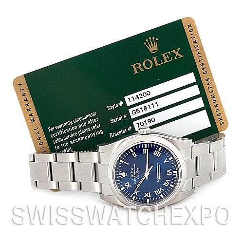 The Rolex Air-King 114200 Men's Stainless Steel Blue Dial 114200 Men's Stainless Steel Blue Dial watch is shown from a front angle, accompanied by the warranty card displaying its model and serial numbers.