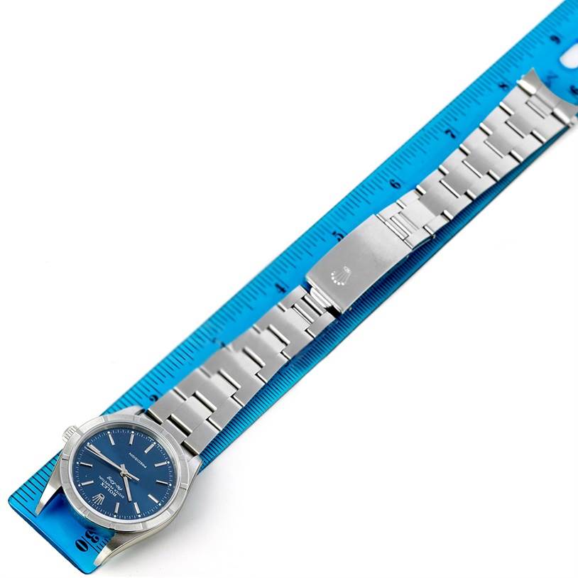 The Rolex Air-King 14010 Men's Stainless Steel Blue Dial 14010 Men's Stainless Steel Blue Dial watch is shown horizontally, displaying the face, bezel, and full metal bracelet alongside a blue ruler.