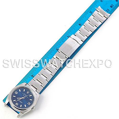 The image shows a top-down view of a Rolex Air-King 114200 Men's Stainless Steel Blue Dial 114200 Men's Stainless Steel Blue Dial watch, including the watch face, bracelet, and clasp, placed next to a blue ruler.