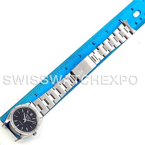 The image shows a Rolex Air-King 14010 Men's Stainless Steel Black Dial 14010 Men's Stainless Steel Black Dial watch laid flat next to a blue ruler, highlighting its entire length and metal bracelet details.