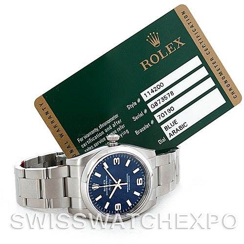 The image shows a Rolex Air-King 114200 Men's Stainless Steel Blue Dial 114200 Men's Stainless Steel Blue Dial watch with a blue dial, a stainless steel band, and its accompanying certification card.