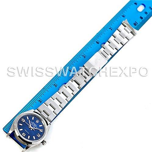 The image shows a side view of a Rolex Air-King 14000 Men's Stainless Steel Blue Dial 14000 Men's Stainless Steel Blue Dial watch with its stainless steel bracelet laid beside a blue ruler.