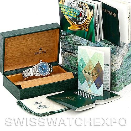 This image shows a Rolex Air-King 14000 Men's Stainless Steel Blue Dial 14000 Men's Stainless Steel Blue Dial watch at an angle revealing the face, bracelet, and crown, inside its box with accompanying booklets and card.