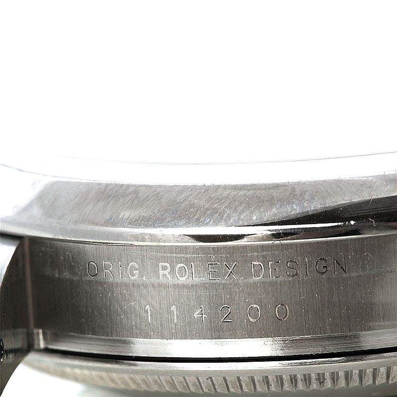 This image shows a close-up of the side of a Rolex Air-King 114200 Men's Stainless Steel Silver Dial 114200 Men's Stainless Steel Silver Dial watch case, focusing on the engraved serial number and design inscription.