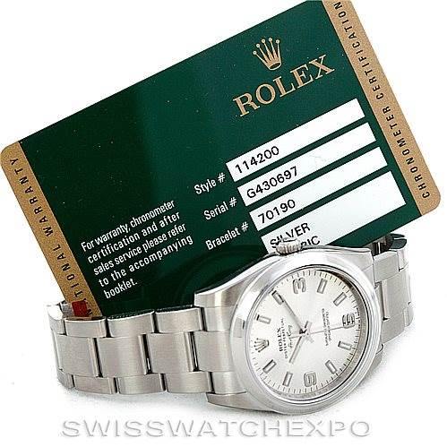 The Rolex Air-King 114200 Men's Stainless Steel Silver Dial 114200 Men's Stainless Steel Silver Dial watch is shown from a front angle, displaying its face and stainless steel bracelet, alongside an official warranty card.