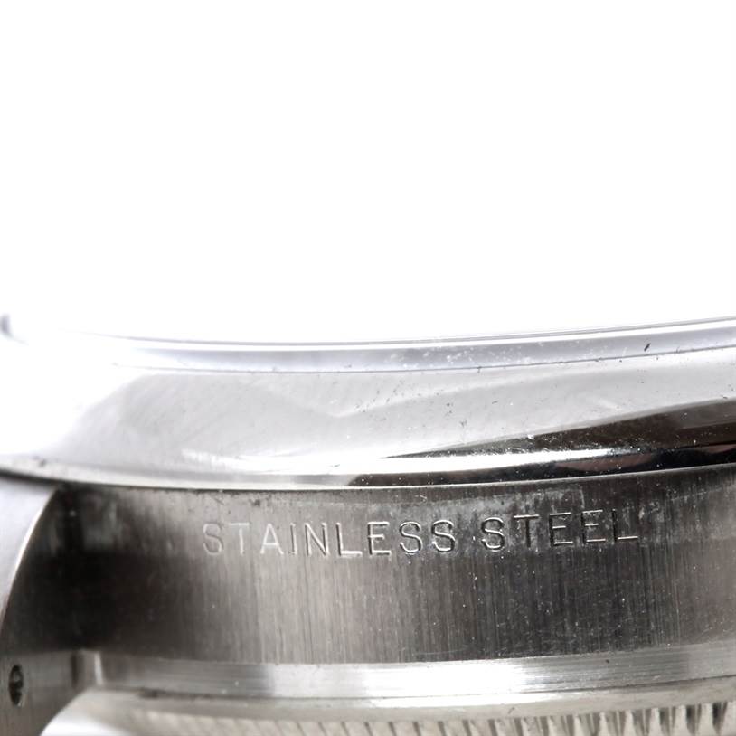 The image shows a close-up of the stainless steel case and the edge of the crystal on the Rolex Air-King 114200 Men's Stainless Steel Silver Dial 114200 Men's Stainless Steel Silver Dial watch.