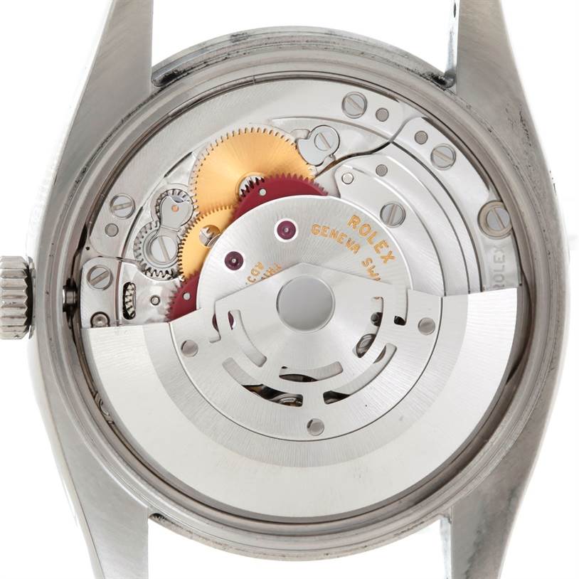 This image shows the internal mechanism and movement of a Rolex Air-King 114200 Men's Stainless Steel Silver Dial 114200 Men's Stainless Steel Silver Dial watch from a back view, with visible gears and components.