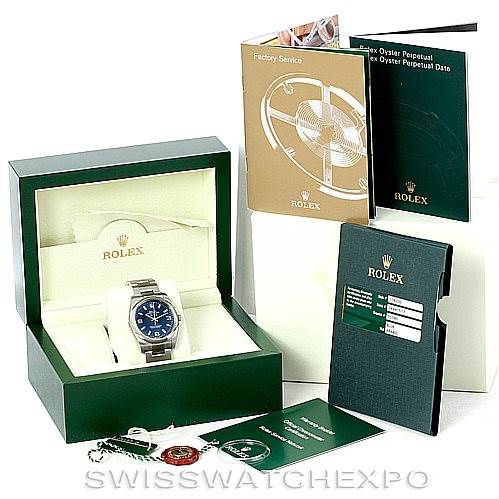 This image shows the Rolex Air-King 114200 Men's Stainless Steel Blue Dial 114200 Men's Stainless Steel Blue Dial watch at an angle inside its green box, along with accompanying manuals, tags, and warranty cards.