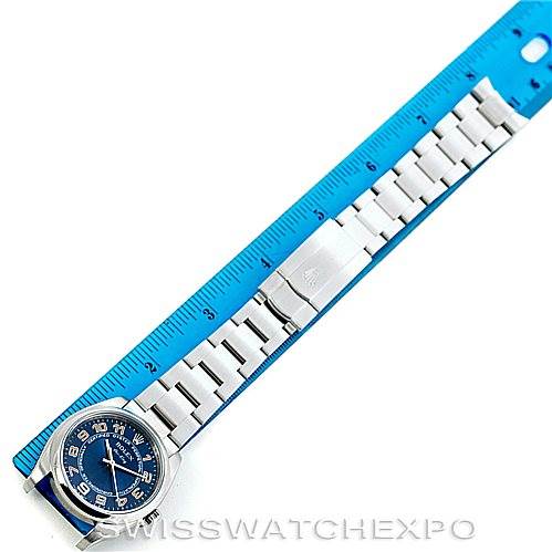 The image shows a top-down view of a Rolex Air-King 114200 Men's Stainless Steel Blue Dial 114200 Men's Stainless Steel Blue Dial watch with its band extended beside a blue ruler for measurement.