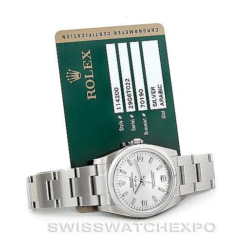 The image shows a Rolex Air-King 114200 Men's Stainless Steel Silver Dial 114200 Men's Stainless Steel Silver Dial watch placed in front of its green certification card, displaying the face and metal bracelet.