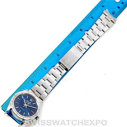 The Rolex Air-King 14010 Men's Stainless Steel Blue Dial 14010 Men's Stainless Steel Blue Dial watch is shown from the front, displaying the face, bracelet, and clasp, with a blue ruler for scale.