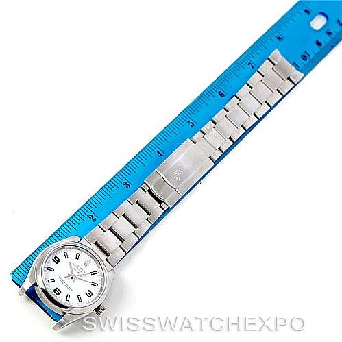 The image shows a top view of the Rolex Air-King 114200 Men's Stainless Steel White Dial 114200 Men's Stainless Steel White Dial watch with its band fully extended beside a blue ruler for size reference.