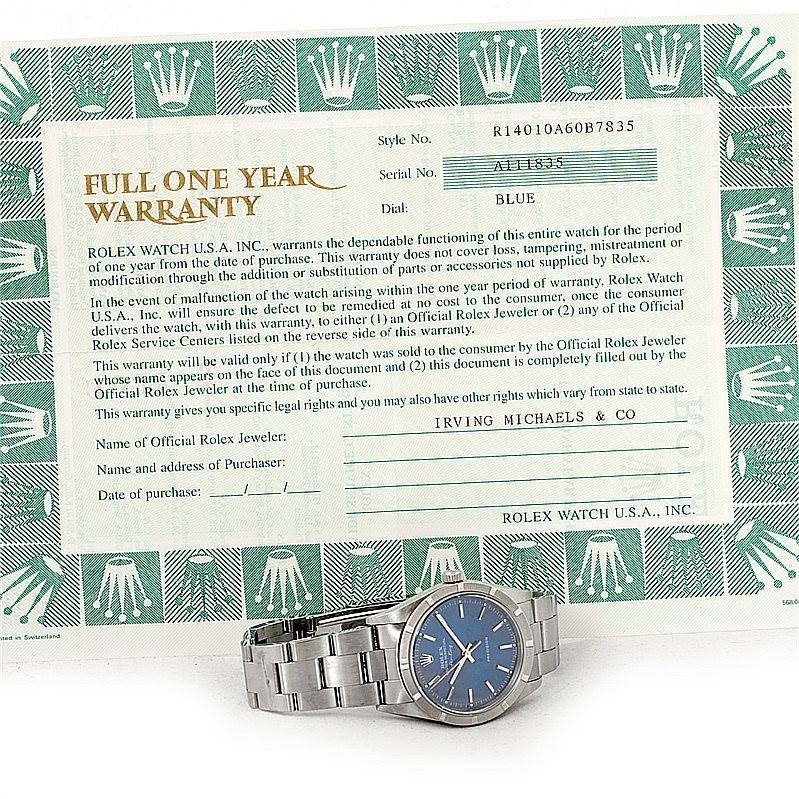 The image shows a Rolex Air-King 14010 Men's Stainless Steel Blue Dial 14010 Men's Stainless Steel Blue Dial watch with a blue dial, placed next to its warranty card from an overhead angle.