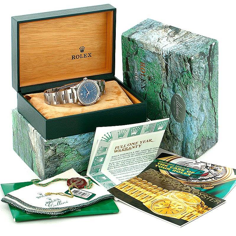 The Rolex Air-King 14010 Men's Stainless Steel Blue Dial 14010 Men's Stainless Steel Blue Dial watch is shown in its box with manuals, warranty card, cleaning cloth, and a green Rolex pouch.