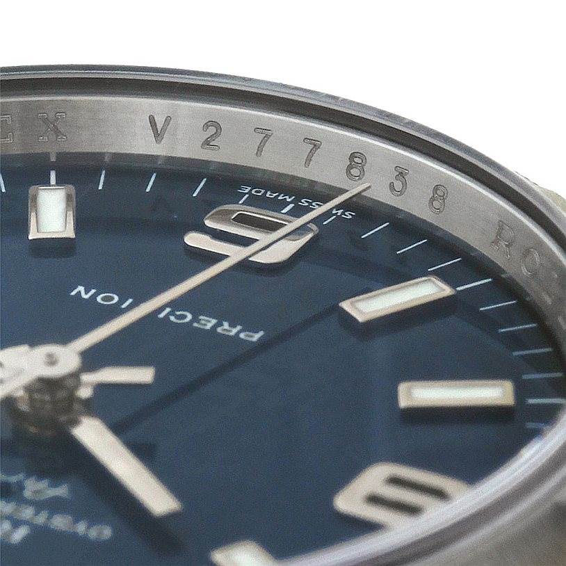 Close-up of the Rolex Air-King 114210 Men's Stainless Steel Blue Dial 114210 Men's Stainless Steel Blue Dial watch face, showing hands, hour markers, and part of the serial number on the inner bezel.